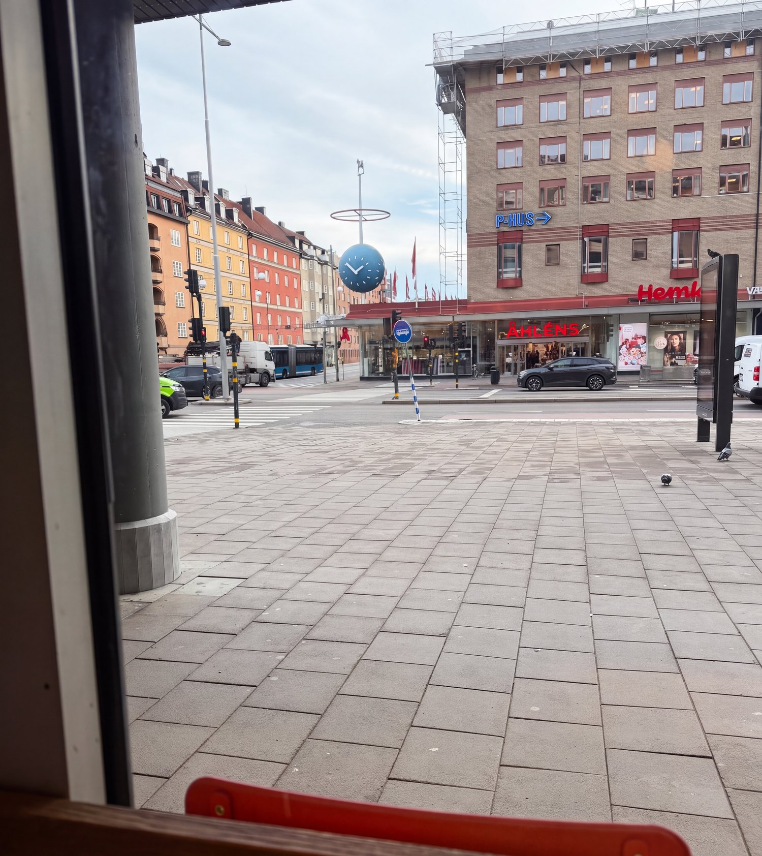 Utsikten från fönsterbaren: torget vid Skanstull med den stora klockan och Åhléns