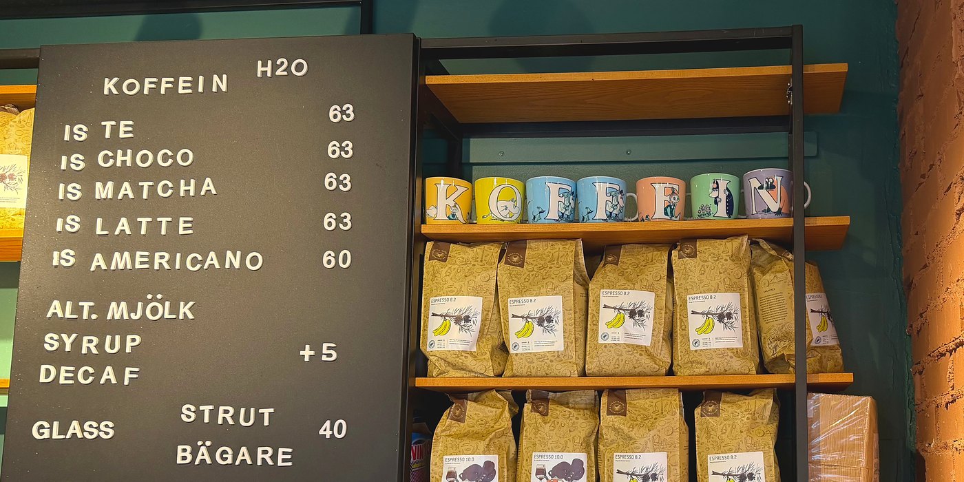Hyllan bakom disken: muggar med bokstäverna K O F F E I N ovanför påsar med Espresso 8.2